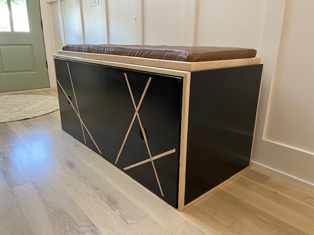 Completed black and maple Window Bench with its worn-leather cushion